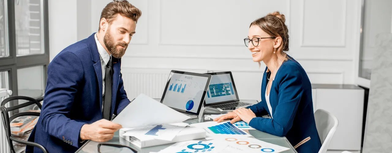 Business professionals reviewing data analytics and project reports while working with an Asana partner in UAE
