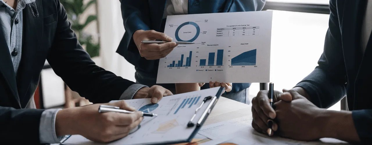 Business professionals collaborating on data analysis during a corporate meeting, reviewing financial reports with donut charts, bar graphs, and area charts for strategic business planning