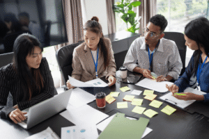 High-angle view of a diverse group of employees organizing project tasks with sticky notes on a desk